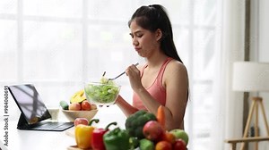 A young Asian woman who eats vegetable salad every day is bored with vegetables. Unhappy women is on dieting time looking vegetable on the fork. girl do not want to eat vegetables and dislike taste.