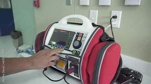 Male doctor demonstrating a defibrillation machine at the hospital