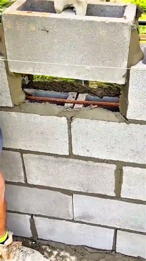 String guides concrete blocks into line; rebar anchors strength beneath fresh mortar