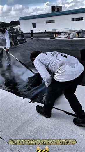 Rolling this roofing membrane over hot asphalt for waterproofing