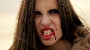 Female vampire with blood starting to attack camera running slow motion extreme closeup