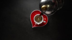 Hot coffee pouring into the cup from the coffee maker