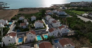 Aerial view of beautiful villas with swimming pools by the sea. Houses in the area on the street are similar to each other luxury housing. High quality 4k footage