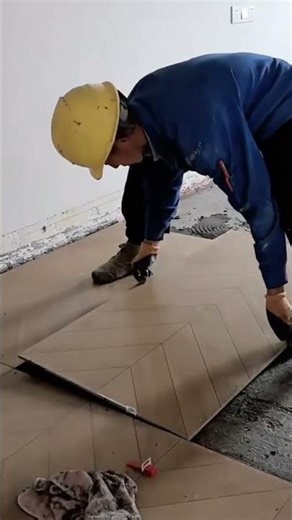 spreading thinset mortar on the floor and back buttering a large tile for floor installation work