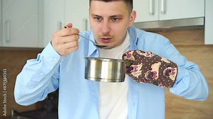A man tastes hot food. Food in a hot saucepan. A man holds a hot pan with an oven mitt