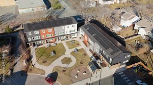 Aerial view of solar panels on the roof of a residential building. Experience future eco-friendly living with our stunning aerial footage capturing solar panels adorning rooftop residential building.