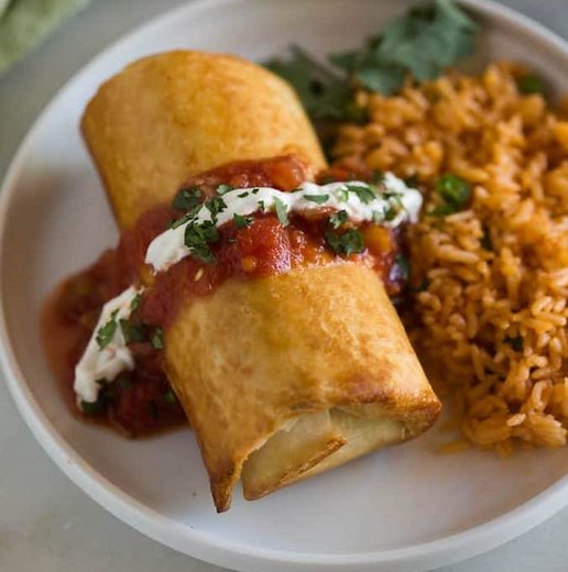 Your family will absolutely love this easy Chicken Chimichanga! Filled with all the good stuff and then pan-fried or baked. Served topped with sour cream, guacamole, and salsa, this Mexican inspired recipe is delicious! https://tastesbetterfromscratch.com/chicken-chimichangas/ | Tastes Better From Scratch