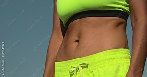 Close up of beautiful girl makes a stomach vacuum yoga asana. Nauli kriya training for the abdominal muscles. Young woman conducts online training during a pandemic. Self-isolation training online.