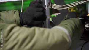 Data center diagnostics technician doing asic mining equipment racks cable management in server room. Network administrator factens wires with plastic clamp in computing cluster with network hardware.