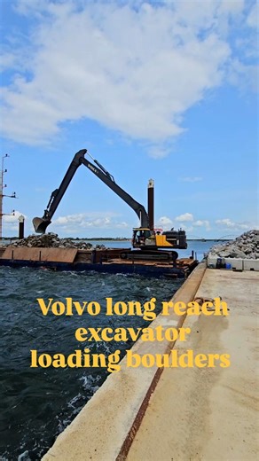 #Volvo #EC480E #longreach #excavator, loading boulders onto a barge, while a #truck is waiting to dump another load. | Danish Construction Channel