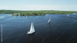 Aerial view of sailing vessels racing one another across picturesque Shelburne harbour, Nova Scotia, Canada. MAX QUAL PRORES422HQ Transcode of 4K H.265 D-CINELIKE original capture.