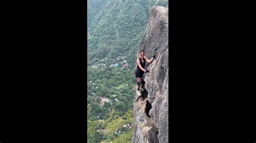 Woman strikes daring poses on a narrow ledge at Mt. Pamitinan in Montalban, Rizal, Philippines