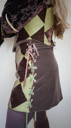 Making the Dust Be Diamonds mini skirt! This piece is not only reversible to a solid green silk dupioni fabric, but it is also adjustable in size by 4” or more! Best fit for waist sizes 32-36”, hips 42-46”. Sizes larger than that range will have more than a 2” lacing gap on each side. [medieval revival, 1960’s fashion, jester, renaissance festival costume, fairytale fashion, fantasy] #1960sstyle #medievalrevival #renfairecostume #jester #fairytalefashion | Lineage Garments