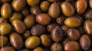 Ripe Ziziphus jujuba fruits with leaves. Chinese date fruits background rotating. Unabi common or Yuyuba Chinese - exotic fruits of jujube tree, closeup, slow motion, flat lay