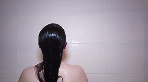 clip-1070143069-woman-washes-her-hair-shampoo-shower-with