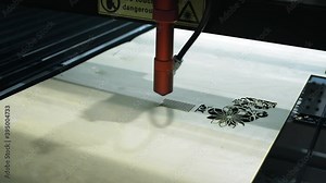 Laser cutting on wood. The laser beam passes through the plywood, cuts out a drawing or pattern. Prepares wooden products. Modern technologies in woodworking.