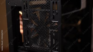 Process of casual keeping computer case clean with dust filter for maintaining efficient airflow and preventing overheating. Closeup of technician cleaning inside of computer case with vacuum cleaner.