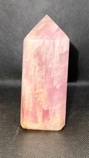 Kunzite is a delicate pink to lilac-colored gemstone belonging to the spodumene mineral family. It is often found in Afghanistan, as well as Brazil, Madagascar, and the United States. Kunzite is known for its exquisite pink to lilac hues, which can range from pale pastel tones to deeper shades. The stone is frequently carved into a tower or obelisk shape, like the one shown, for use in spiritual practices. Kunzite is associated with the heart chakra and is believed to promote emotional healing, 