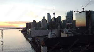 4K Aerial flight at Toronto harbourfront rotating around and looking at Toronto skyline at sunset with Billy Bishop Airport in the background