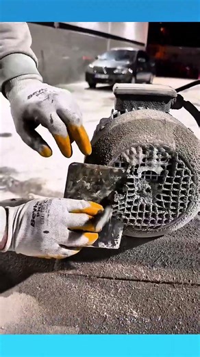 A thick layer of dust is scraped off an electric motor’s vent, revealing the grid beneath