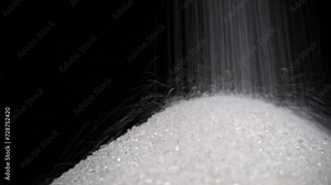 White sand streams onto the sugar pile. Sweets are harmful to health. Sugar addiction. Nutrition and diet control. Sugarless. Diabetes. Weight gain from sweets.