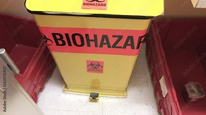 Medical biohazard waste disposal container in hospital clinic room.