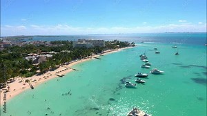 Drone video of Playa Norte or North Beach on the island of Isla Mujeres, Mexico. A beautiful beach with white sand and shiny turquoise water around it