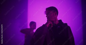 Two Young Dancers, Male and Female, Deliver a Stunning Synchronized Modern Dance Performance, Dancing with Grace and Precision in their White Outfits, Against a Digital Colorful Screen Stock Video