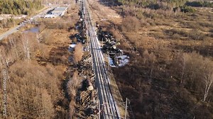 Train wreck on the railroad, scattered tanks from collision. Aerial view of the accident - a crash with damaged wagons lying next to the rails. Workers - rescuers carry out repair work.