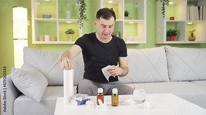 Flu, sneezing man. Sick man. The mature man covers his mouth with a napkin while sneezing. Flu and colds.