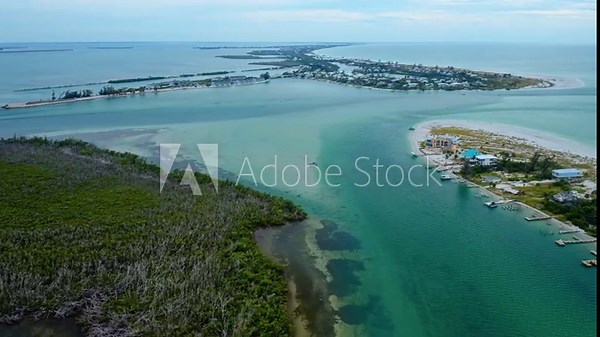 Waterfront homes and mangroves border the shallow turquoise water of Stump Pass Inlet near Manasota Key on Florida’s Gulf Coast, with docks, sandbars, and shifting tidal channels shaping the scene. 素材庫影片