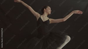 Elegant ballet dancer in black tutu showcases grace and artistry in movement, embodying essence of performance and elegance within studios artistic atmosphere.