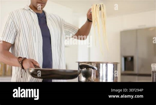 Man is lifting spaghetti from cooktop pot, lowering into pan and tossing to coat in sauce. Culinary, homecooking, modernkitchen, stainlesssteel, kitchenware, gastronomic, foodpreparation Stock Video Footage - Alamy