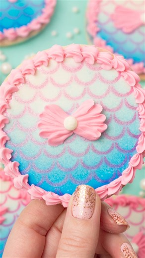 I've only used my airbrush a handful of times so I haven't mastered the teqnique yet, but I'm having fun with it! I iced these mermaid-inspired cookies in flood consistency royal icing and let the icing dry overnight before airbrushing them. I used my @silhouette.inc cutting machine to create the mermaid scales stencil The stencil holder is from @thesweettesttiers #royalicingart #decoratedcookies #sweetambscookies #royalicingcookies #mermaidthemeparty | SweetAmbs