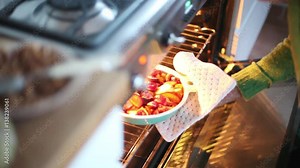 Woman taking baked fruit dish out of oven