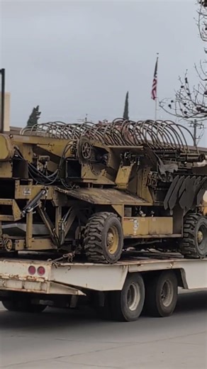 An Asphalt Shuttle Buggy used in road construction to store, remix, continuously feed hot mixasphalt