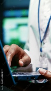 Vertical video Extreme close up shot of experienced IT programmer using laptop to audit high tech facility security to protect information access, making sure virus protection software is updated