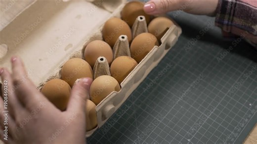 Female hands opening carton box and takes farms eggs. Easter, tradition, holiday and people concept