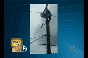 Homem sobe em um poste de fiação elétrica e manuseia os fios sem proteção alguma