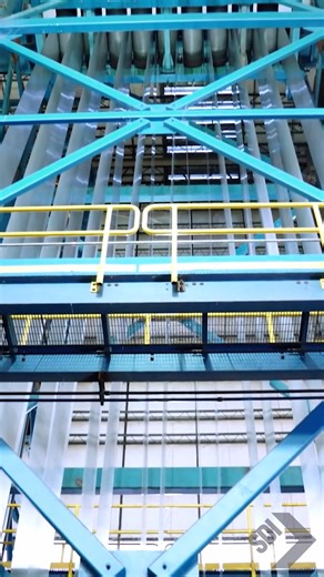 The accumulator is one of the most important pieces of machinery in any continuous flat roll steel operation. Placed near the beginning and end of the production line, it “accumulates” hundreds of feet of material at the tail end of a coil. The tail of the coil is then held stationary while the line runs through the material in the accumulator, buying time for the head end of the next coil to be precision-welded to it. This process joins both coils into one “continuous” strip before the first co