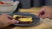 A person spreading yeast extract spread onto toast and placing an...