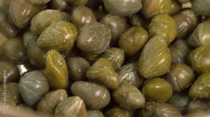 Pickled marinated capers rotate in macro. Ingredients for making spicy sauce, tartare or salad
