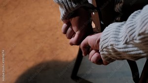 Hands of a man handcuffed to a chair trying to break free Stock Video