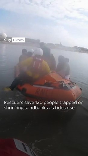 Footage from the RNLI shows numerous people on sandbanks at Rhyl beach as the tide rises around them #Beach #Rescue #SkyNews | Sky News