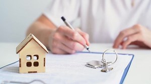 Handing over the keys of a house by a real estate agent to a young couple in love who rented or bought an apartment