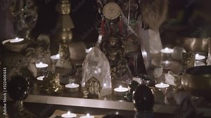 Close up of Feng Shui altar at home in living room on the table. Art. Attracting wealth and prosperity concept, rystal clusters, golden Buddah figure and candles.