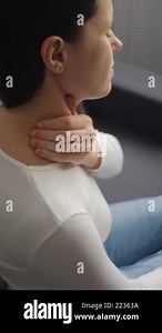 Vertical footage of tired young caucasian woman painful with neck pain body ache from work, holding massaging rubbing shoulder hurt, sore sitting on couch at home. Pain body muscles stiff problem Stock Video Footage - Alamy