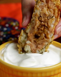 If you love burritos, you’ll love this ooey-gooey, golden-fried spin. A cross between a burrito and arancini, this recipe features taco-spiced ground beef and cheese wrapped in layers of refried beans and cilantro-lime rice, then coated in crushed tortillas chips and fried to golden-brown perfection. Recipes: https://tasty.co/recipe/burrito-bombs | Tasty