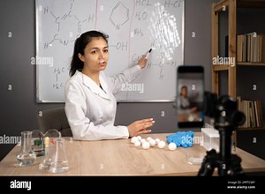 Female teacher making video lecture teaching chemistry online pointing on blackboard with formulas at home. E-teaching and educational blogging Stock Photo - Alamy