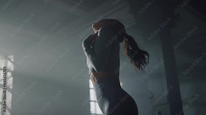 Girl performing exercises to warm up neck. Muscular woman stretching neck